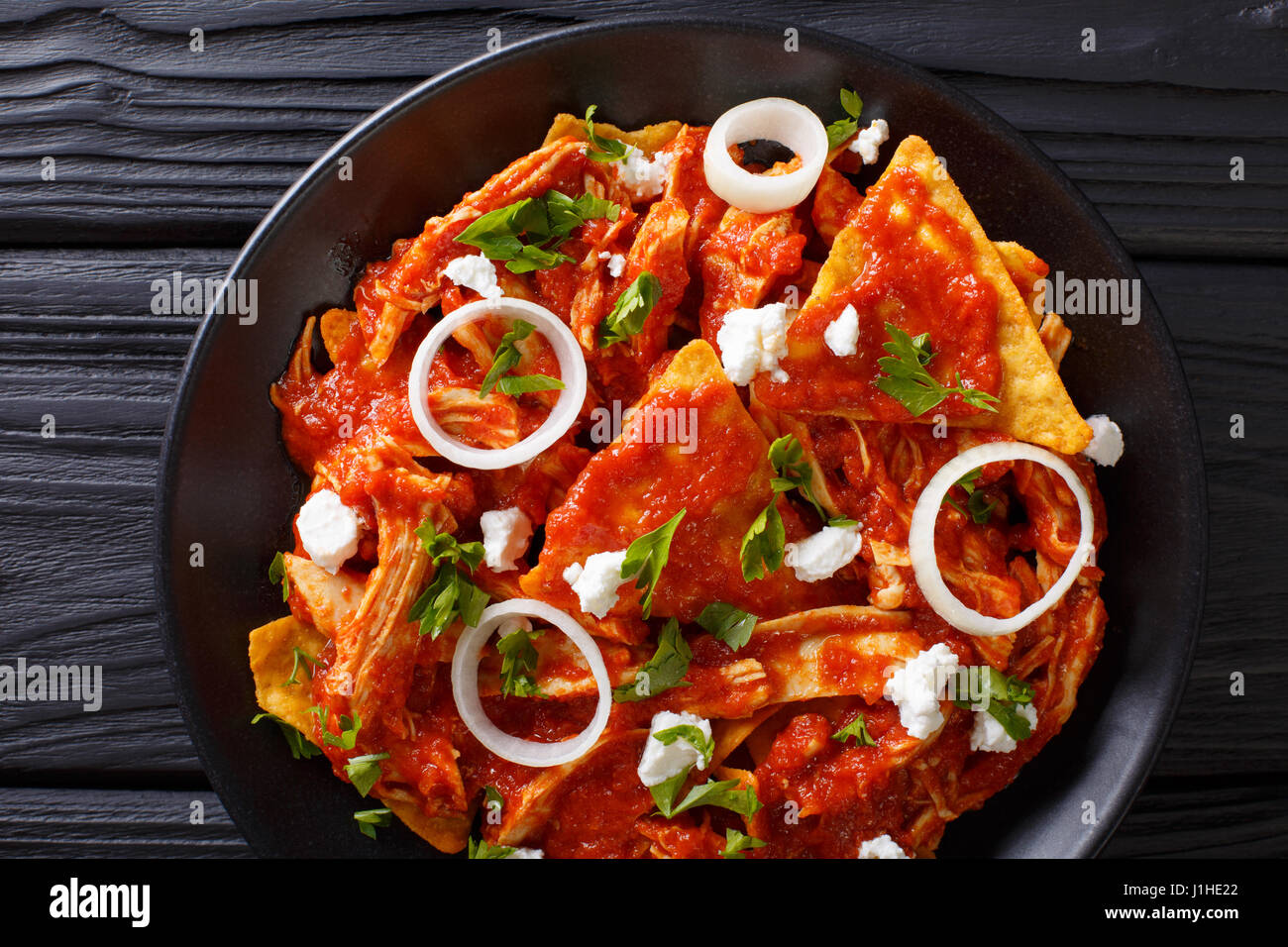 Hot Mexican food chilaquiles with chicken close-up on a plate on the table. Horizontal view from above Stock Photo