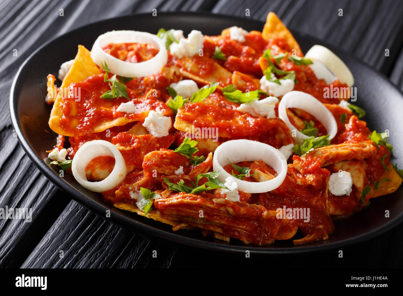 Mexican food fried tortillas with chicken and tomato salsa closeup on a plate on a table. horizontal Stock Photo