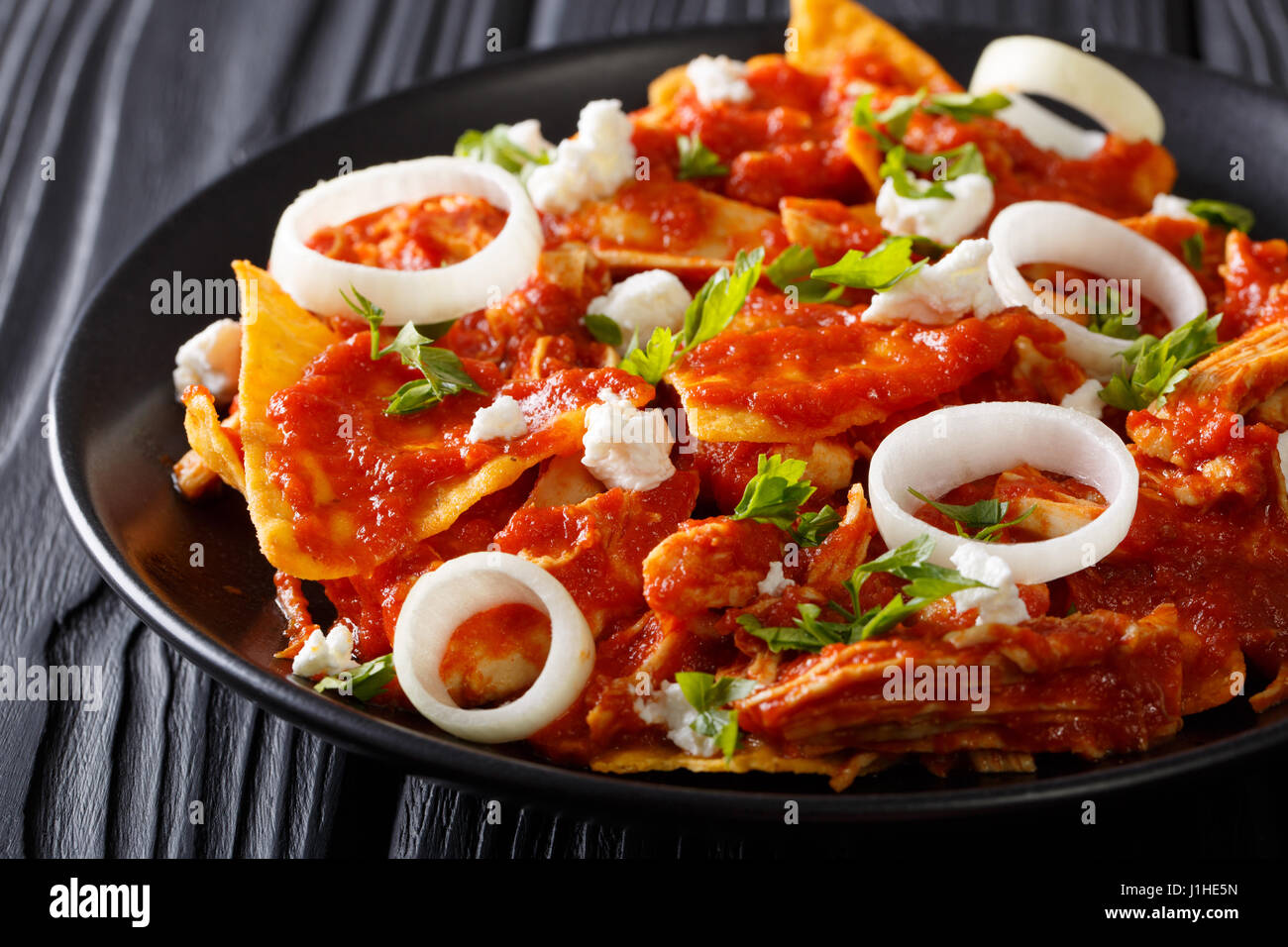 Hot Mexican food chilaquiles with chicken close-up on a plate on the table. horizontal Stock Photo