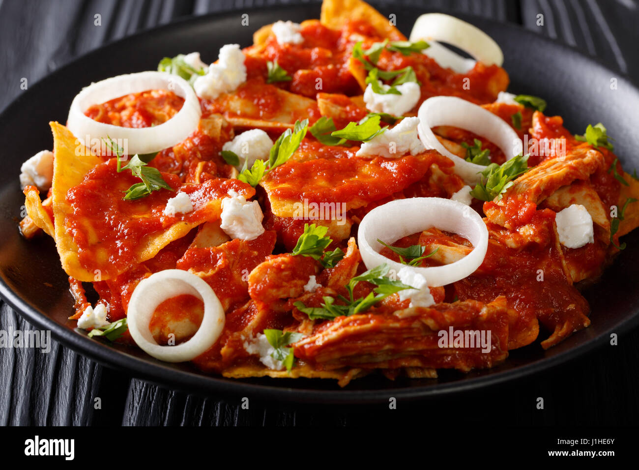 Delicious mexican food: nachos with tomato salsa, chicken and cheese close-up on a plate. horizontal Stock Photo