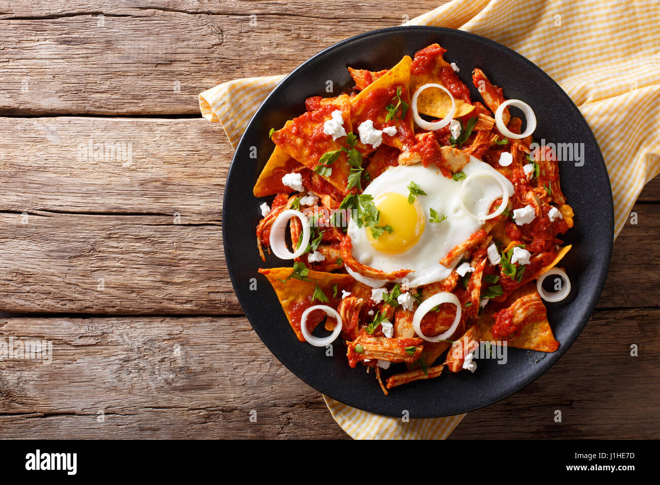 Mexican nachos with tomato salsa, chicken and egg close-up on a plate. Horizontal view from above Stock Photo