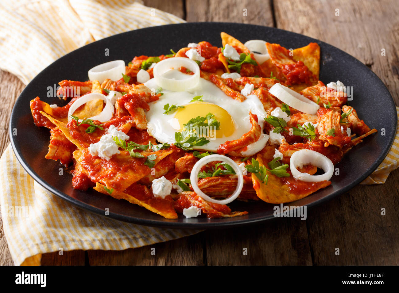 Mexican nachos with tomato salsa, chicken and egg close-up on a plate. horizontal Stock Photo