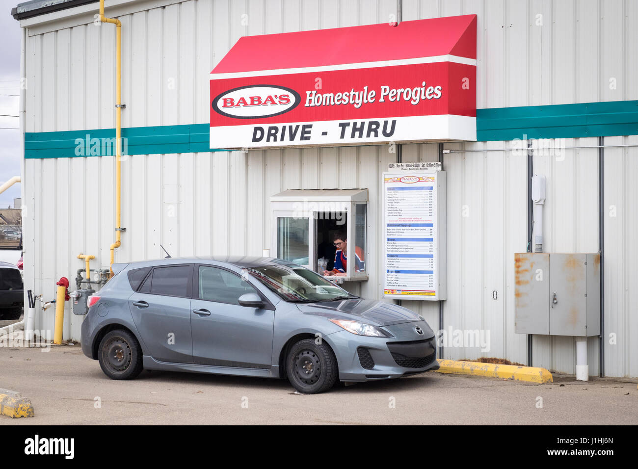A drive-thru customer at the drive-thru window at Baba's Homestyle Perogies in Saskatoon, Saskatchewan, Canada. Stock Photo