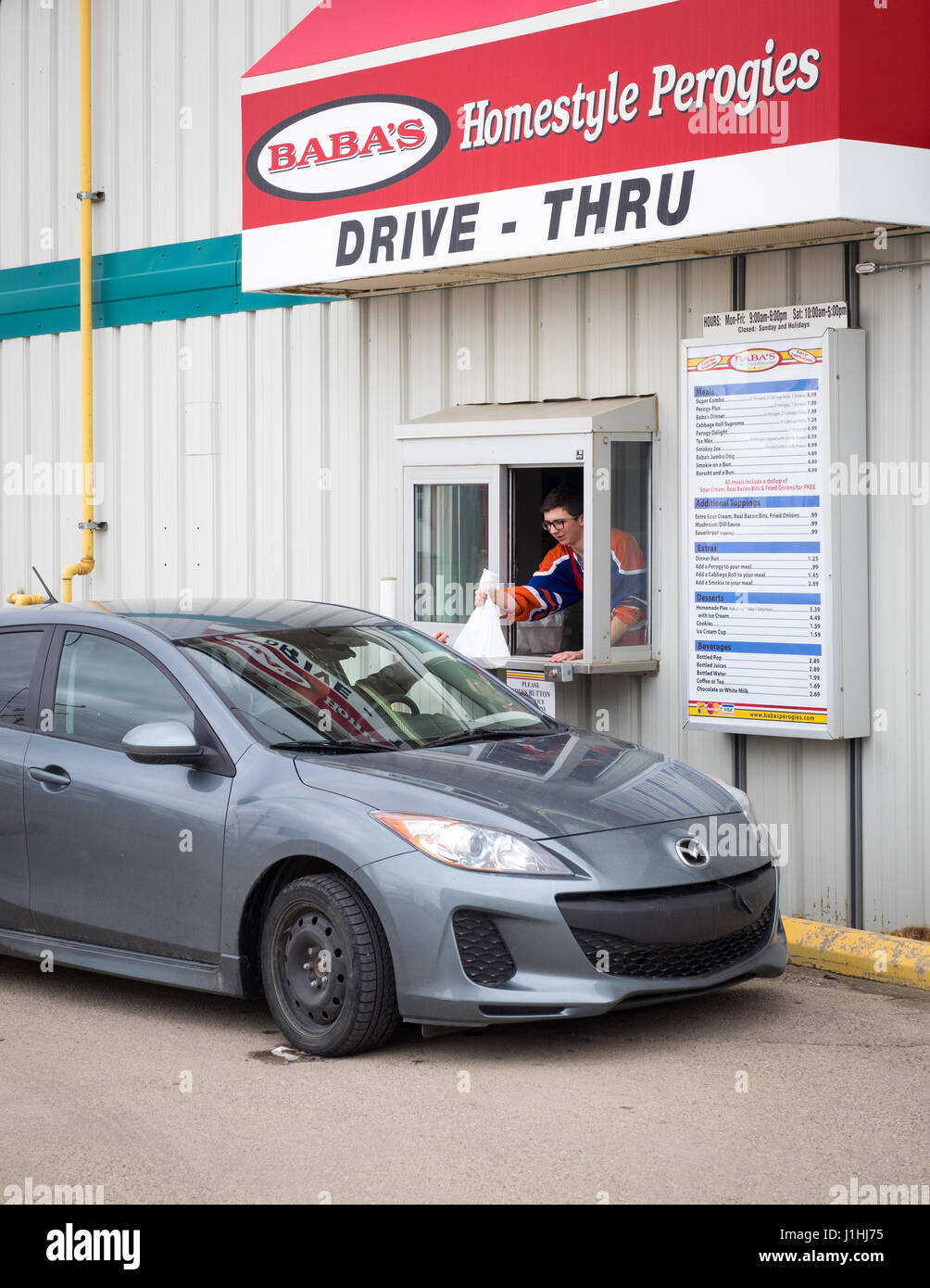 A drive-thru customer at the drive-thru window at Baba's Homestyle Perogies in Saskatoon, Saskatchewan, Canada. Stock Photo