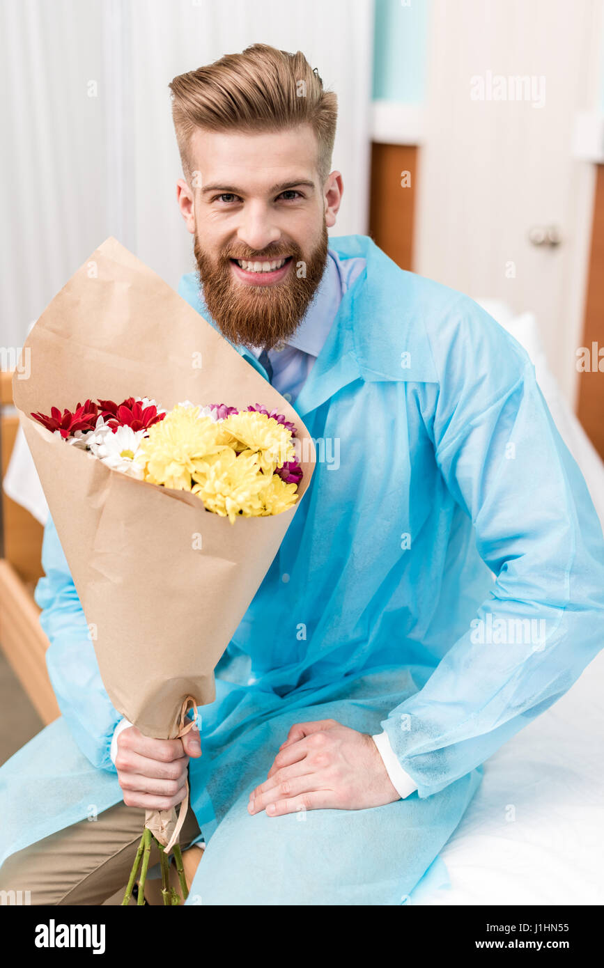 front view of happy young man with flowers in hospital Stock Photo Alamy