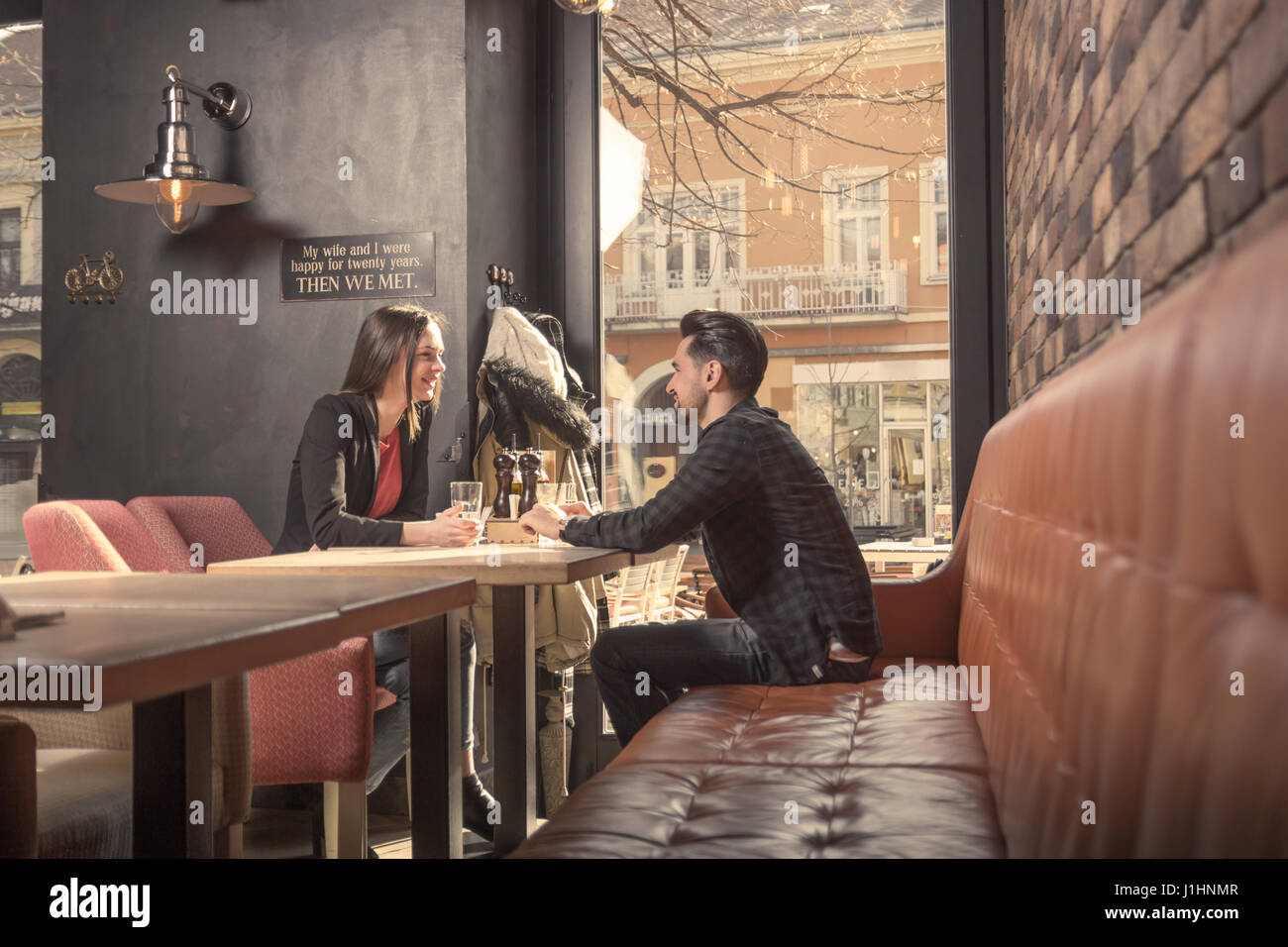 young woman man couple friends, sitting table cafe shop interior ...