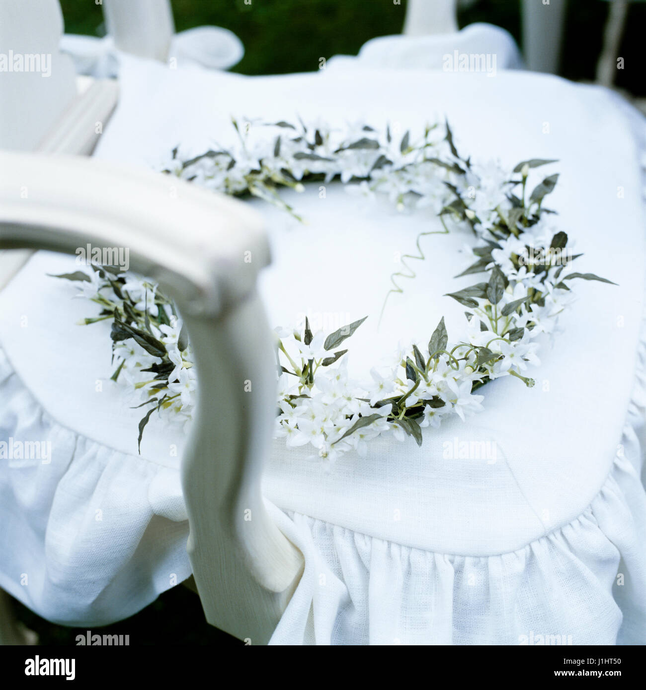 Wreath of white flowers on chair. Stock Photo