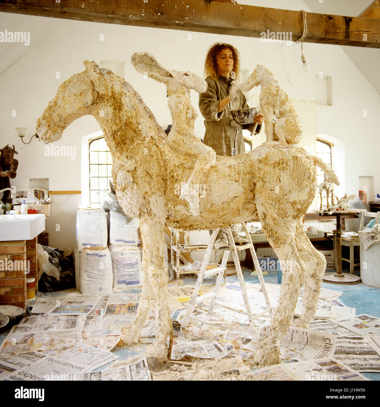 Woman working on sculpture in studio. Stock Photo