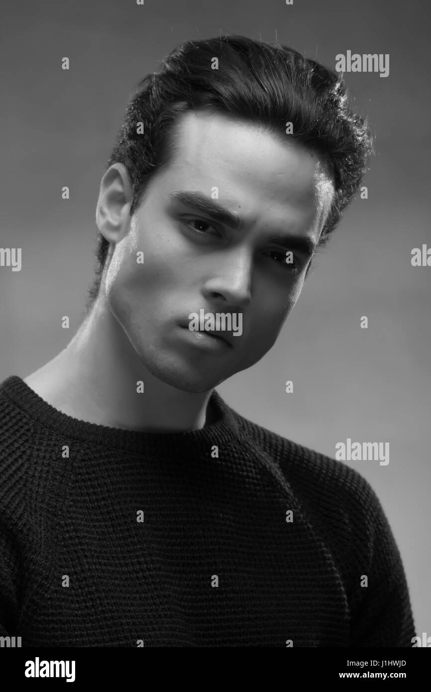one young man posing, black and white image, sweater, looking at camera Stock Photo