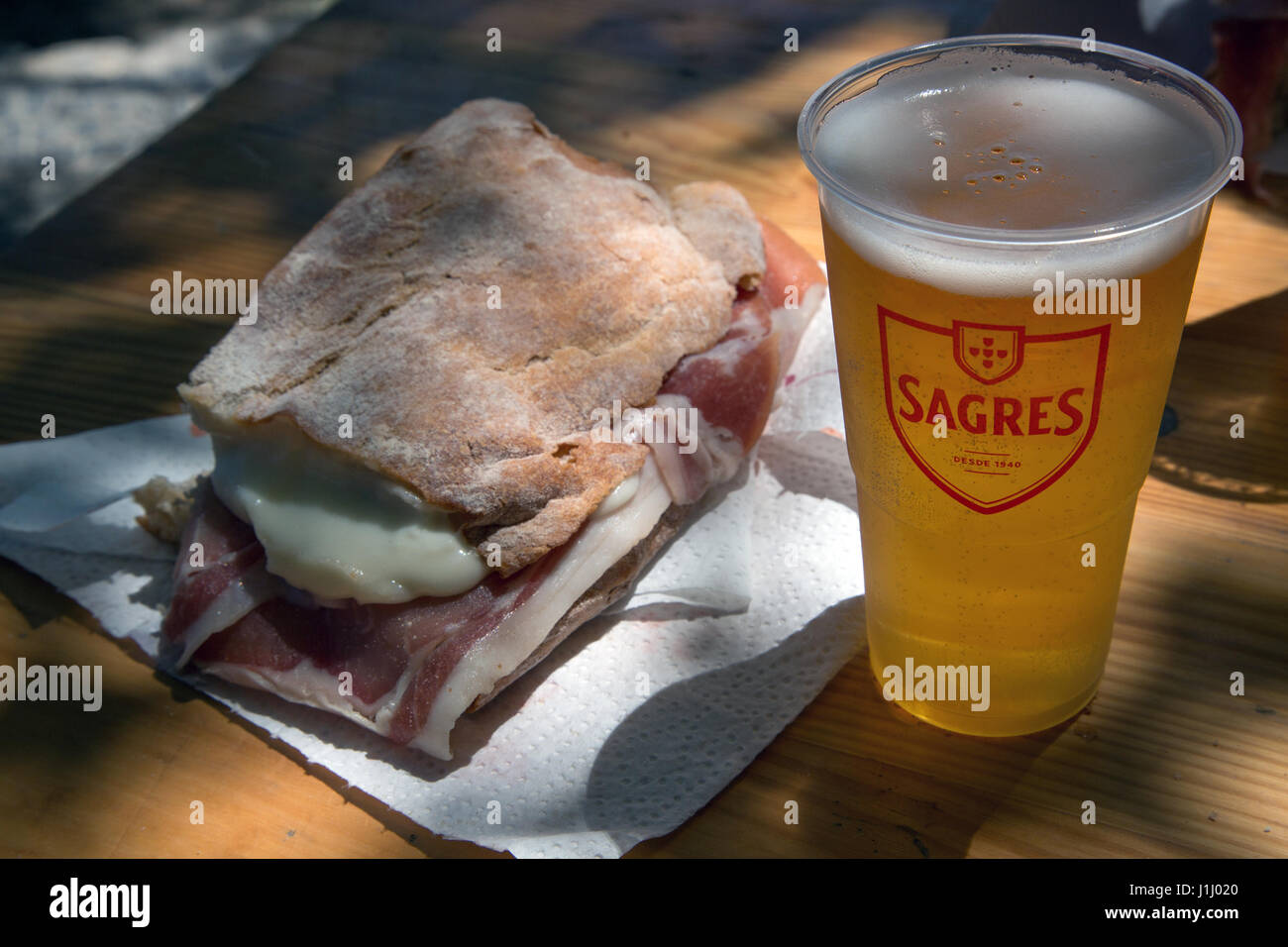 A ham and cheese sandwich and a Sagres larger drink. Stock Photo