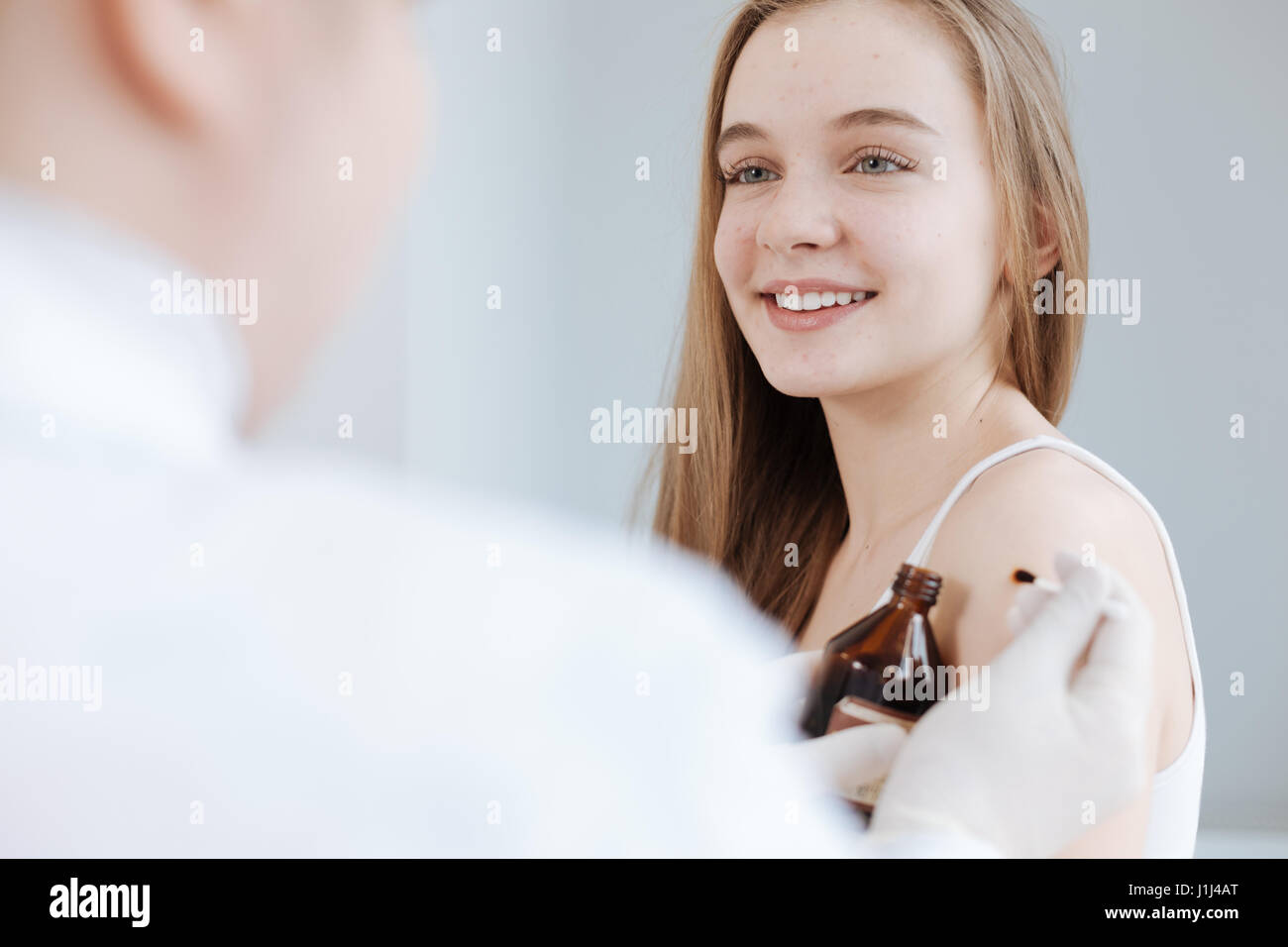 Amused teenager enjoying visit to the dermatologist in the clinic Stock Photo