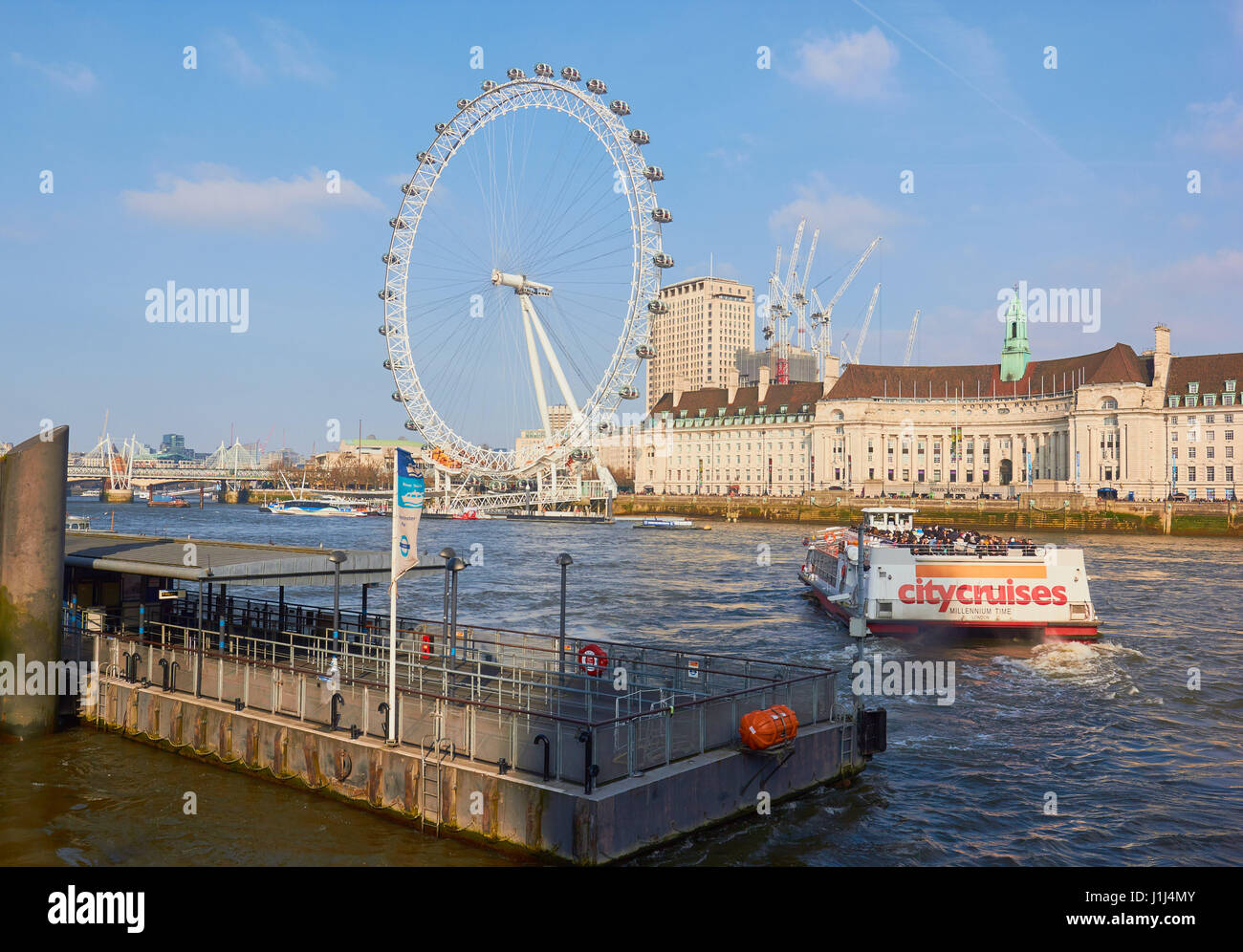 Millennium Wheel and river cruise boat from Westminster Pier, London, England Stock Photo