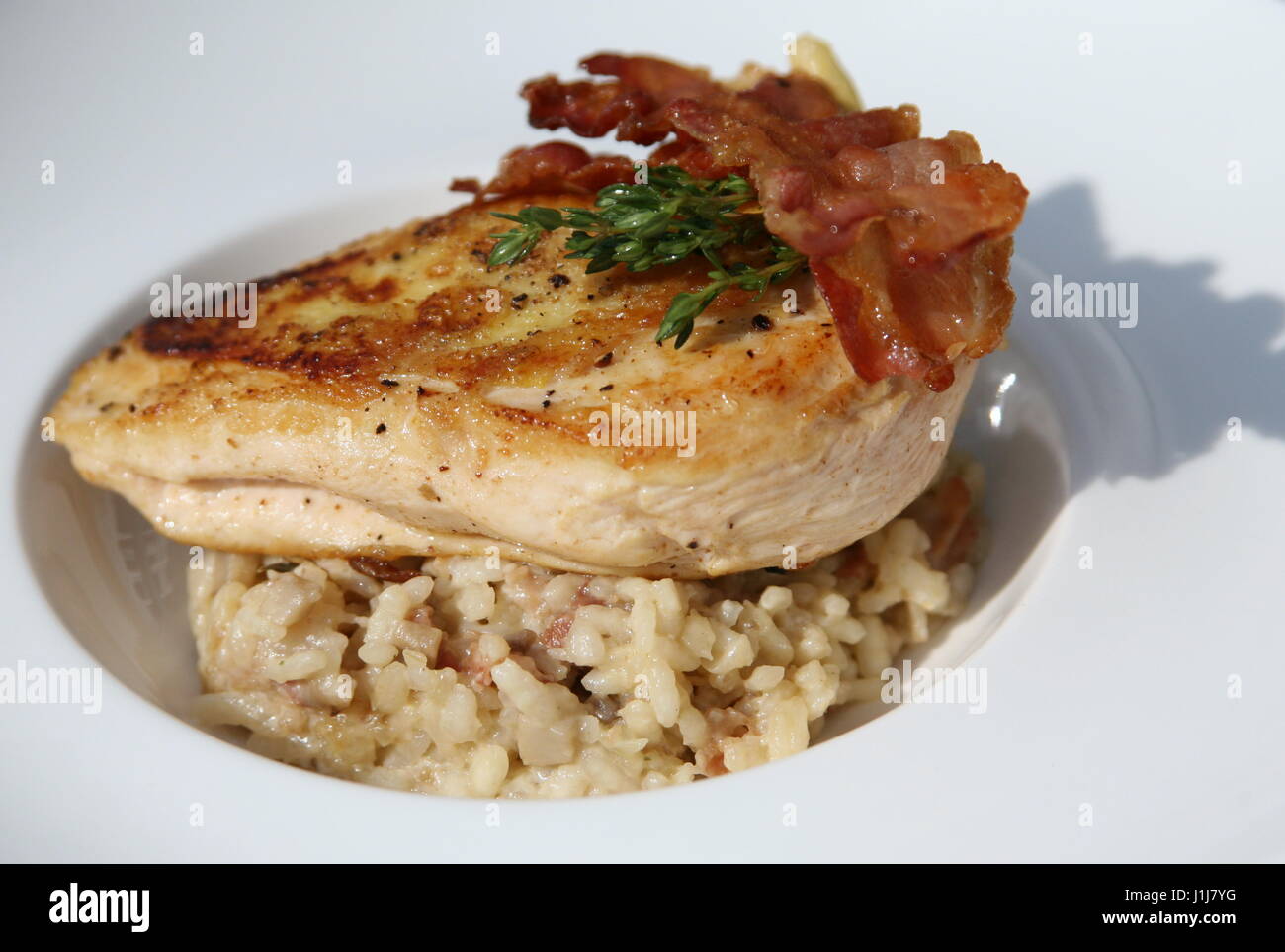 A chicken and bacon dish served on top of rice Stock Photo