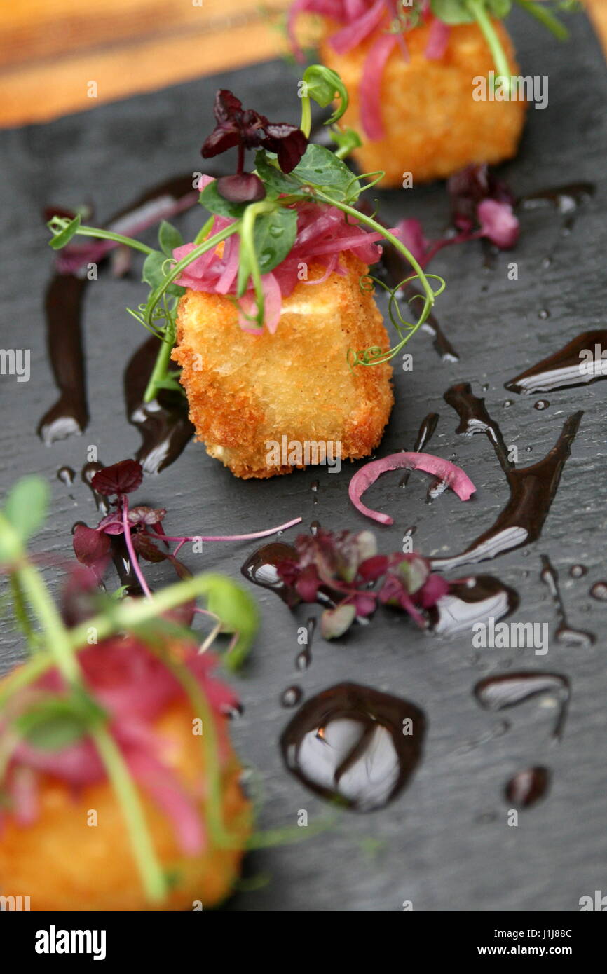 Trio of feta cubes on a slate plate Stock Photo