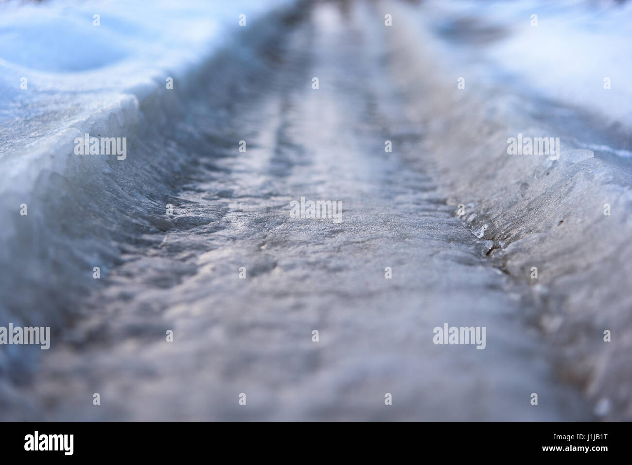 Ice covered frozen road closeup Stock Photo