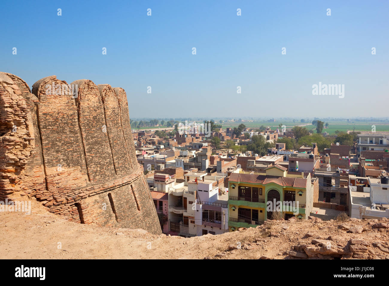 restored walls at bhatner fort with a view of hanumangarh town and surrounding agricultural countryside in rajasthan india under a blue sky Stock Photo