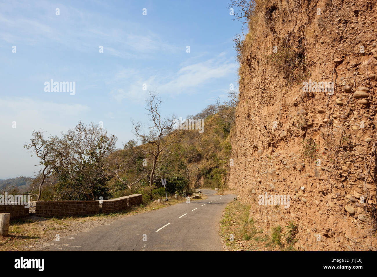 mountain road through the nature reserve of morni hills chandigarh india with sandy cliffs hills