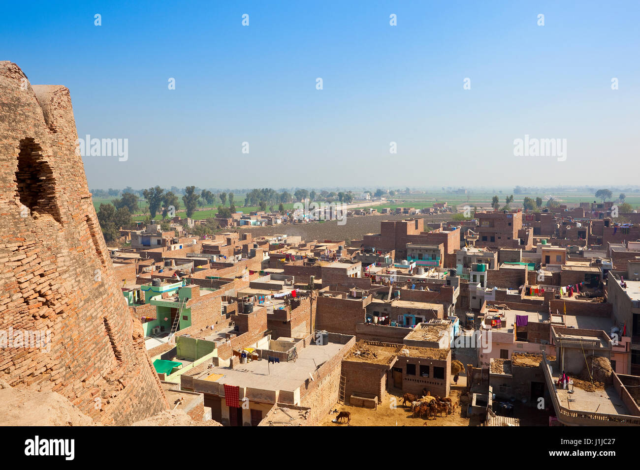 daily activities in the suburbs of hanumangarh city viewed from the restored walls of bhatner fort rajasthan with surrounding farmland under a blue sk Stock Photo