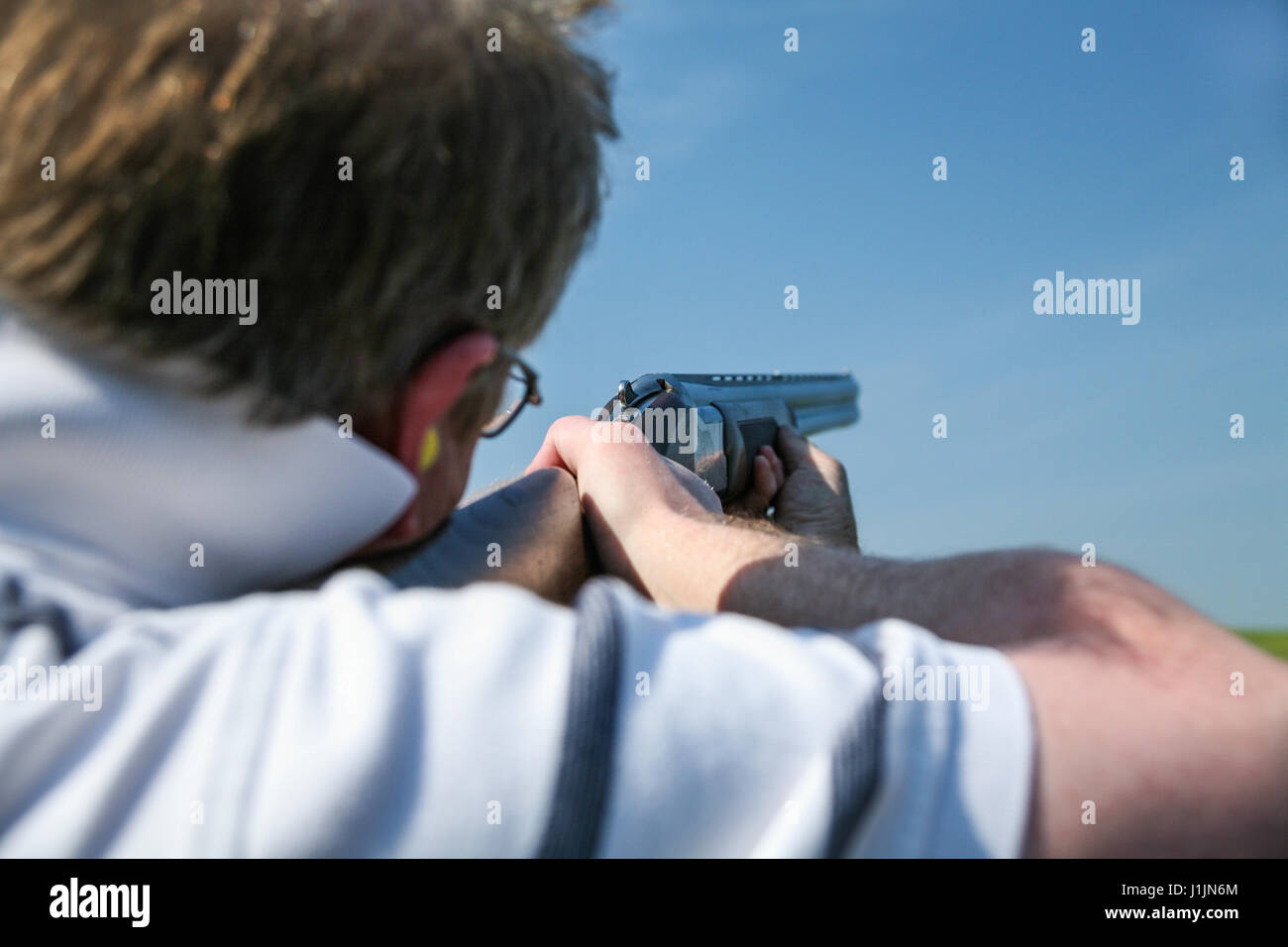 Man aims rifle ready to shoot clay pigeon Stock Photo