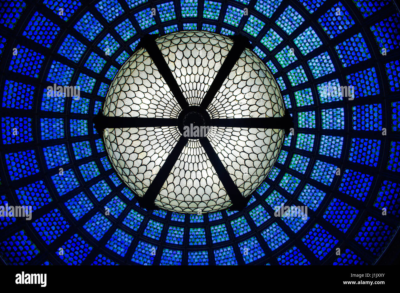 Glass dome, glass ceiling in the Cultural Center, Chicago. The intricate ceiling is made from blue stained glass. Pattern is circular and ornate. Stock Photo