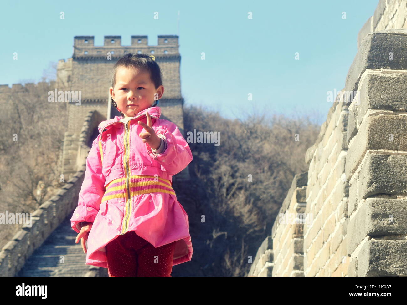 Cute Chinese girl in traditional clothes at Great Wall of China, Mutianyu, Beijing Stock Photo