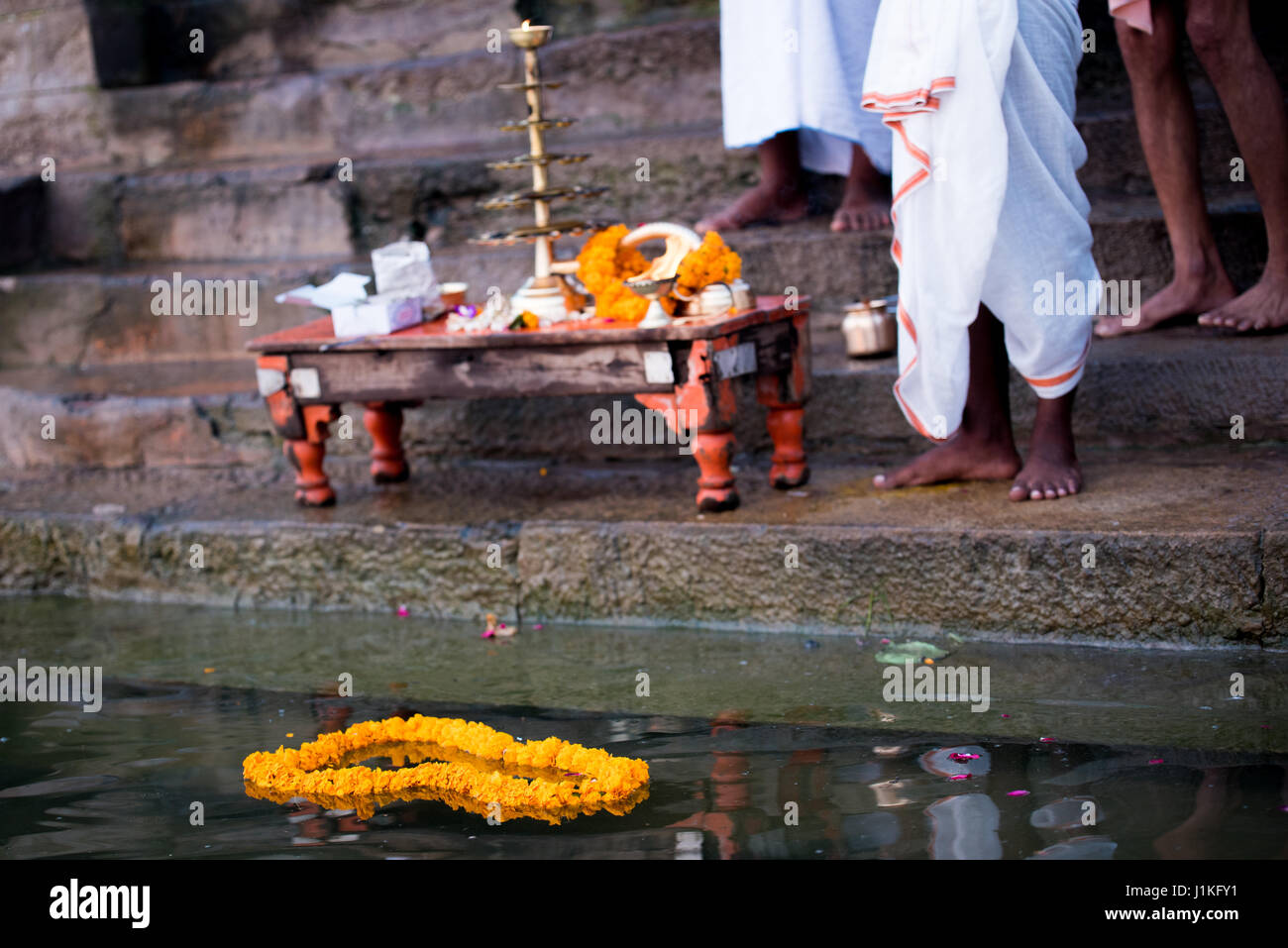Men praying at an early morning ceremony at the river Ganges in Varanasi, India Stock Photo
