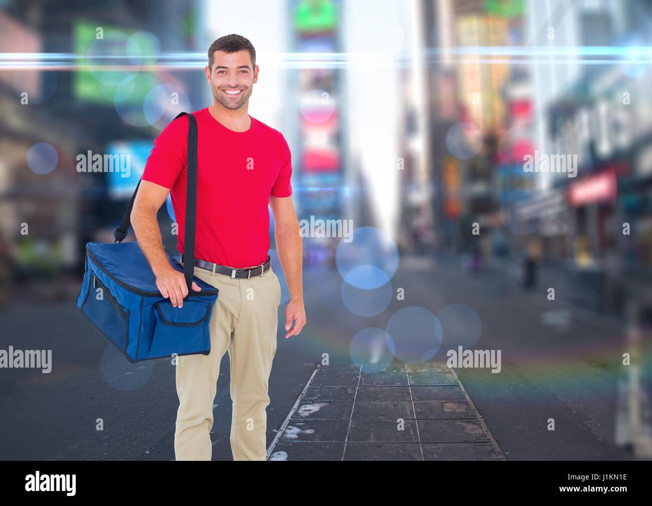 Digital composite of Happy pizza deliveryman with delivery bag in the city with lights Stock Photo