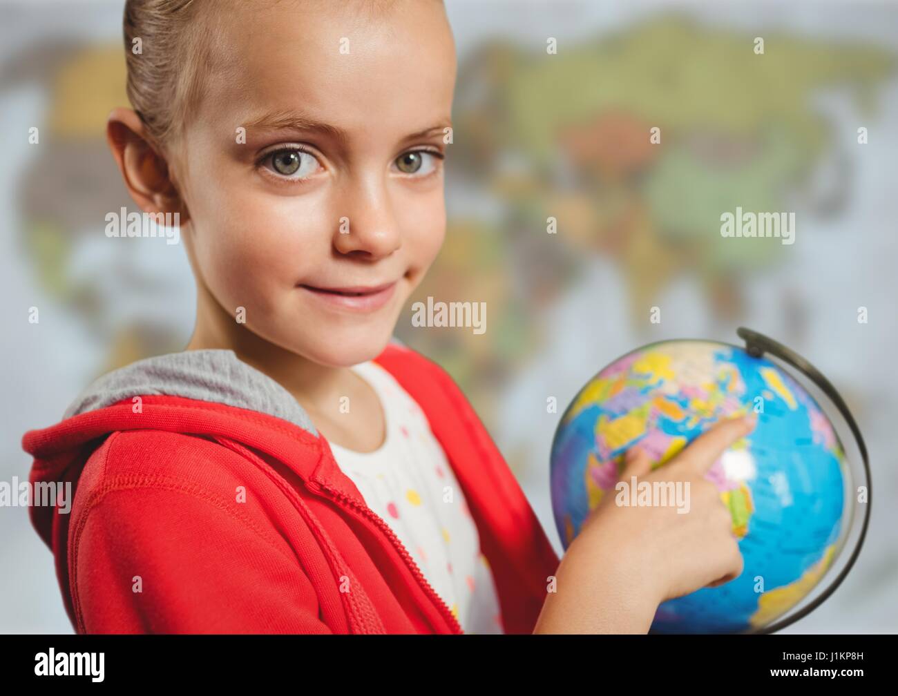 Digital composite of Girl with globe against blurry map Stock Photo