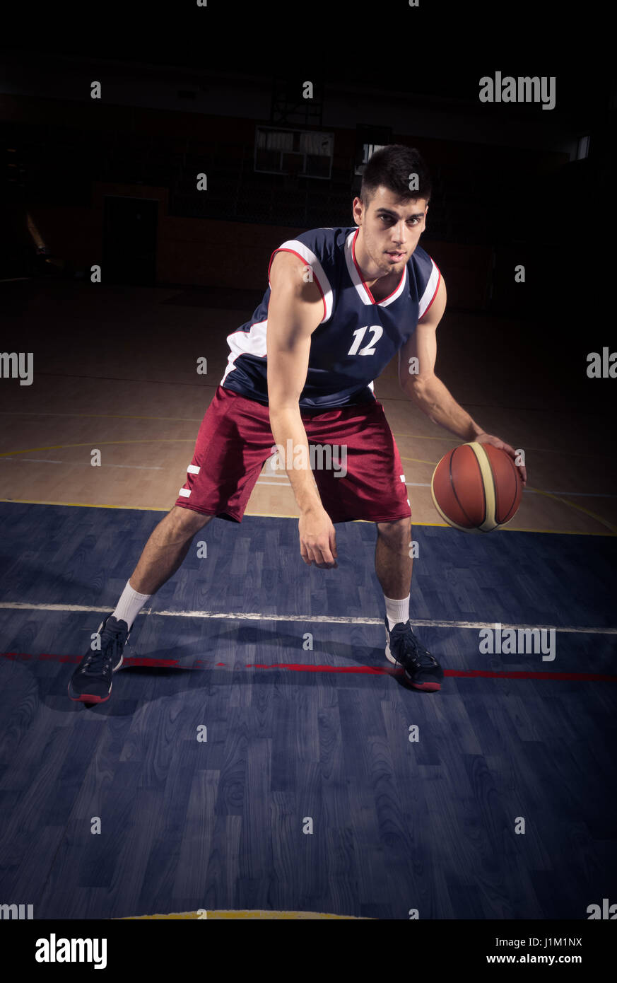 one young man, basketball player dribble ball, indoors court Stock Photo