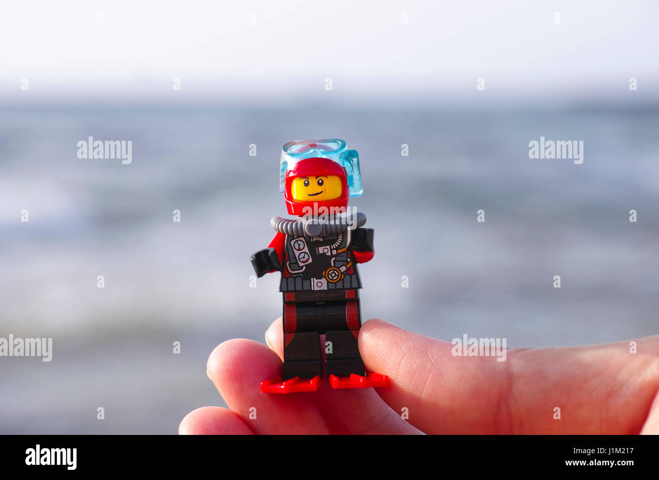 Paphos, Cyprus - October 08, 2016 Lego scuba diver minifigure in woman fingers with sea background. Stock Photo