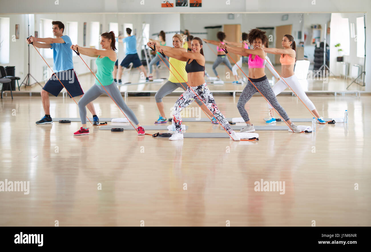 Fitness practicing group uses resistant rubber in gym Stock Photo