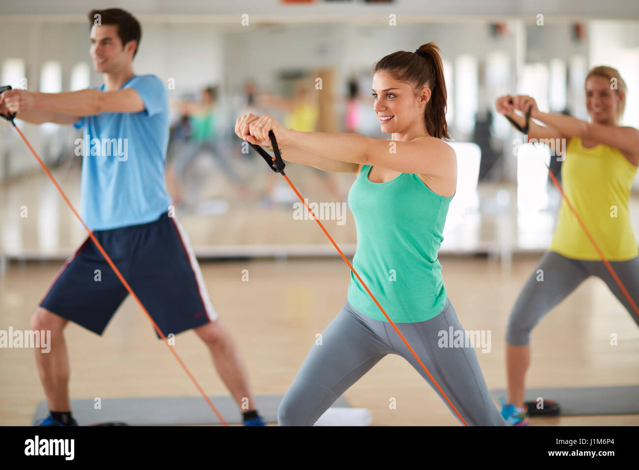 Cute girl exercising with resistant rubber in fitness class Stock Photo