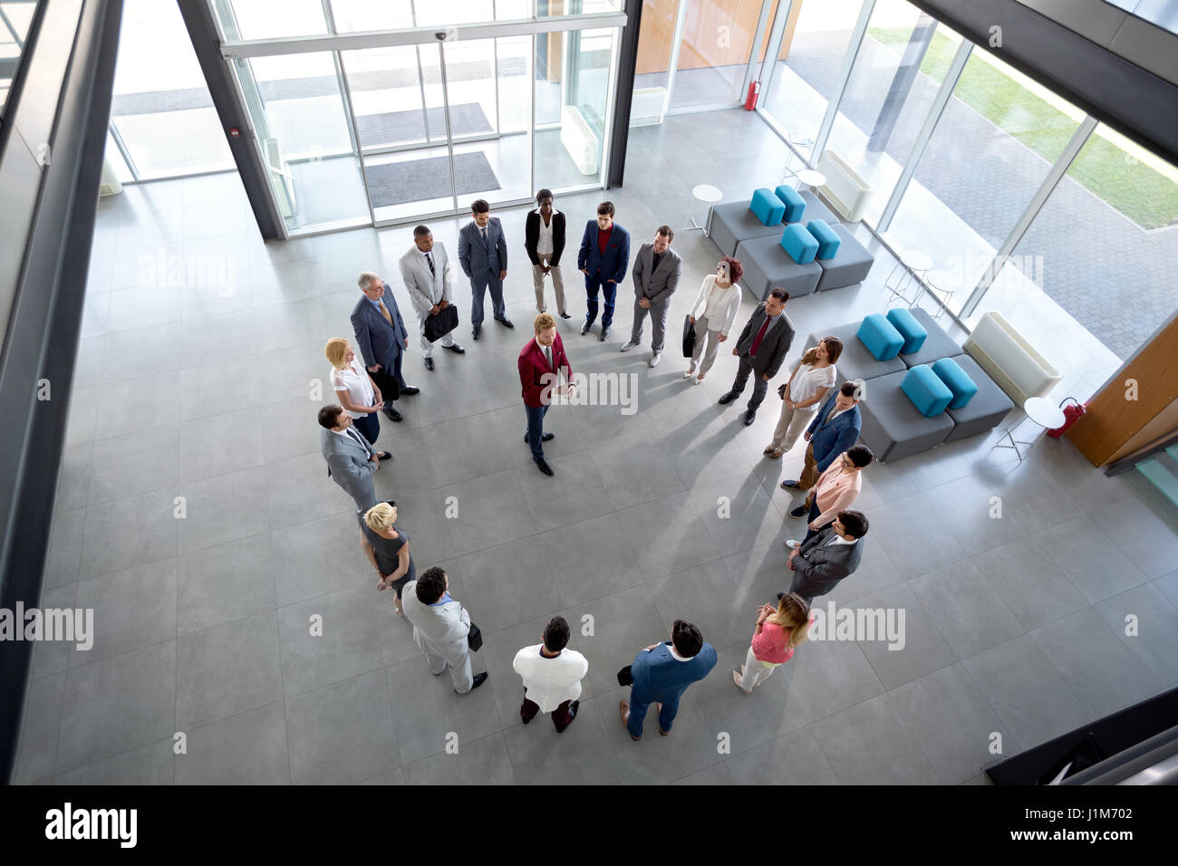 Young director has meeting with employees in circle in company hall Stock Photo