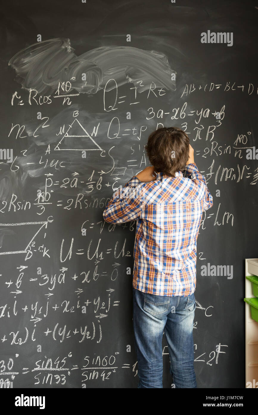 Boy writting on black board Stock Photo