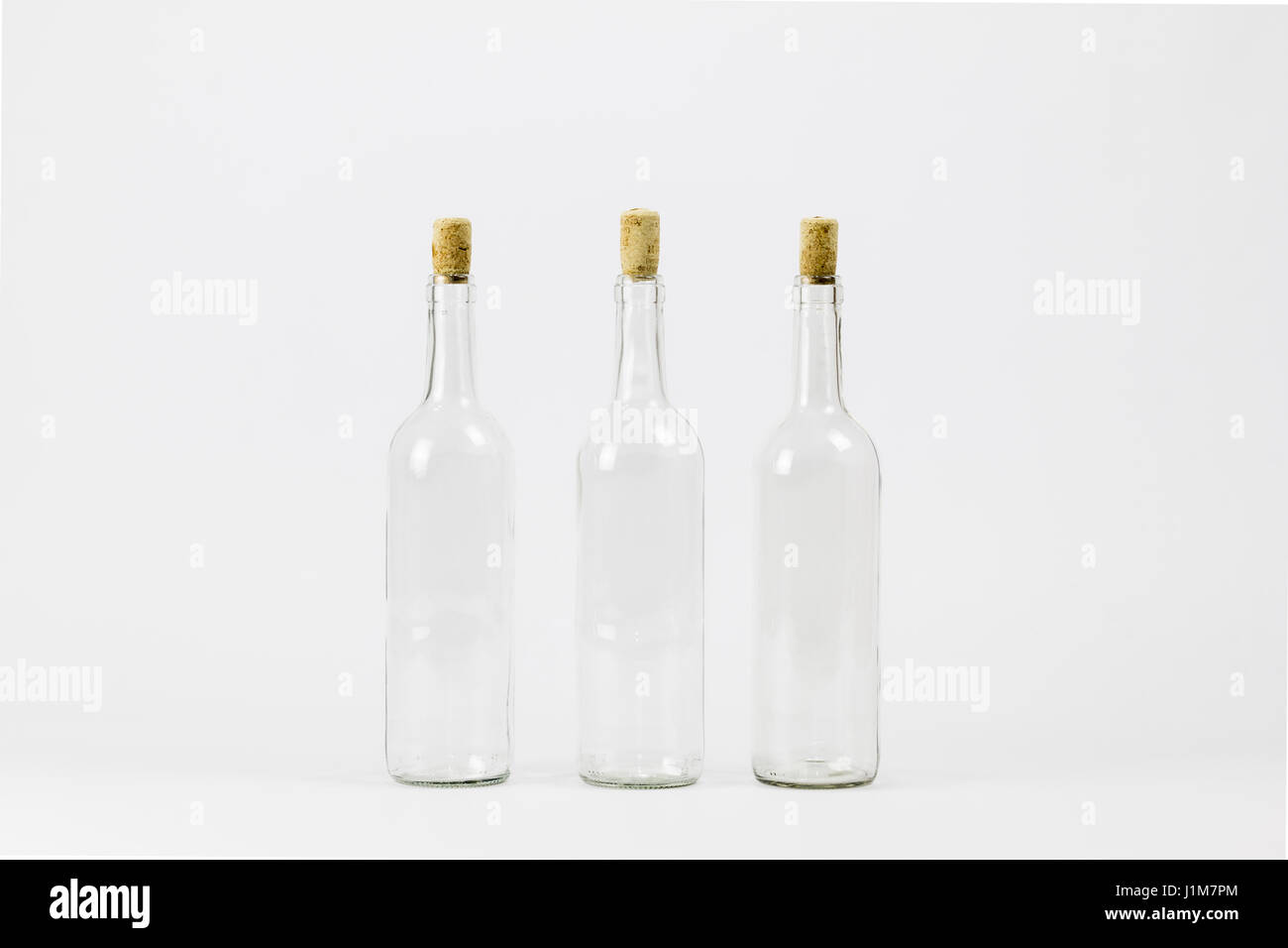 Three empty glass bottle with cork isolated on white background Stock