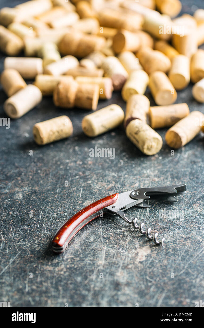Corkscrew and corks on old table. Stock Photo