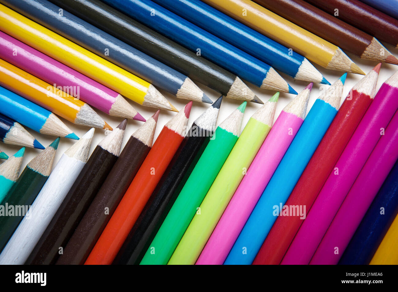 lots of colored pencils on white paper background image to add your own text if you want Stock Photo