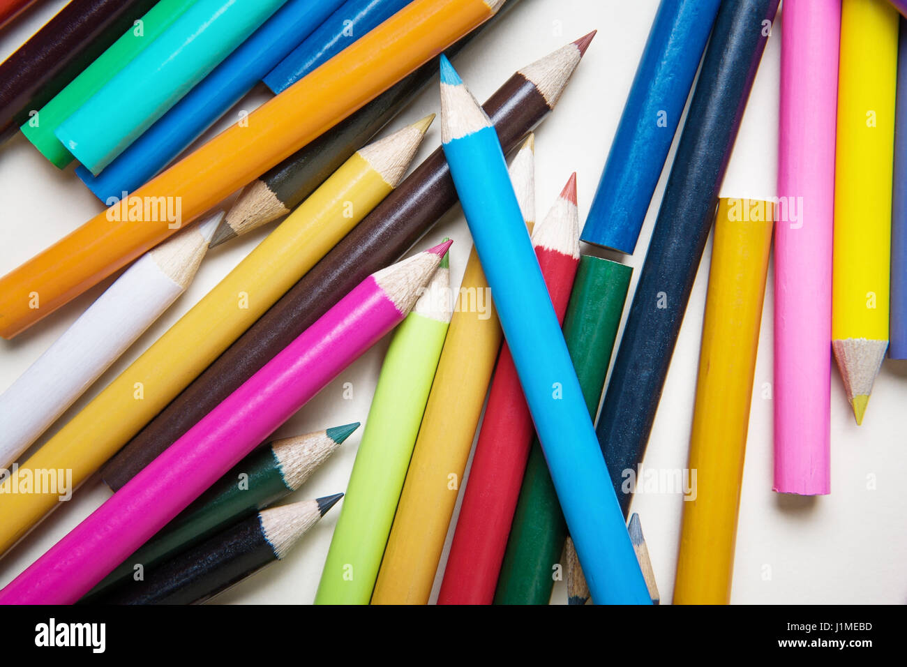 lots of colored pencils on white paper background image to add your own text if you want Stock Photo