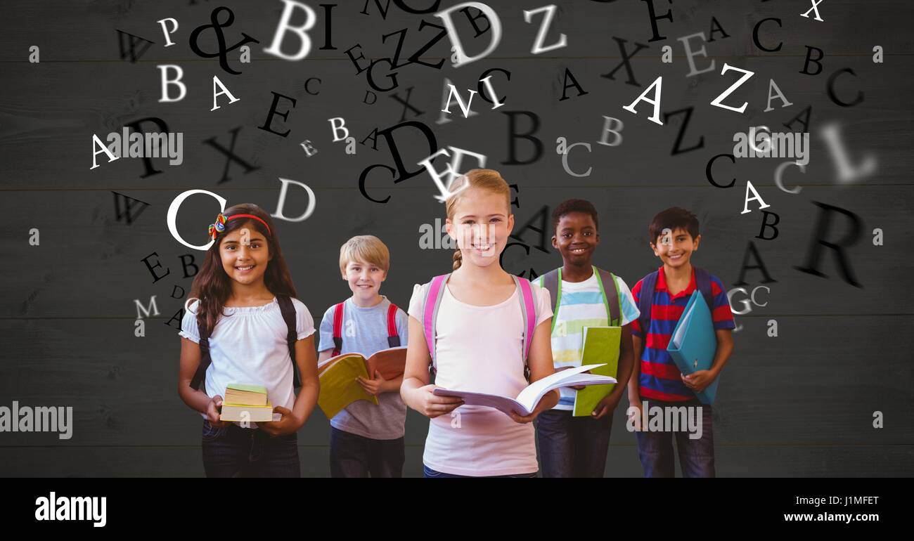 Digital composite of Happy school children holding books while letters flying Stock Photo