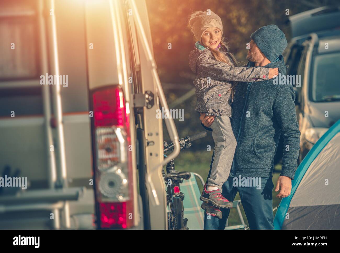 Father Daughter and the Campsite. Family Fun Concept Photo. Camper Van and the Tent. Stock Photo