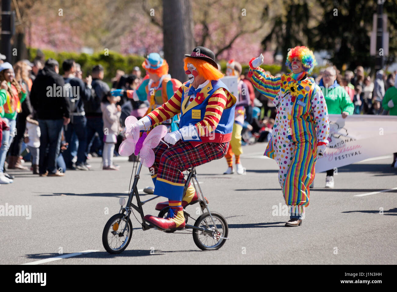 Clown riding  bike during street parade - USA Stock Photo