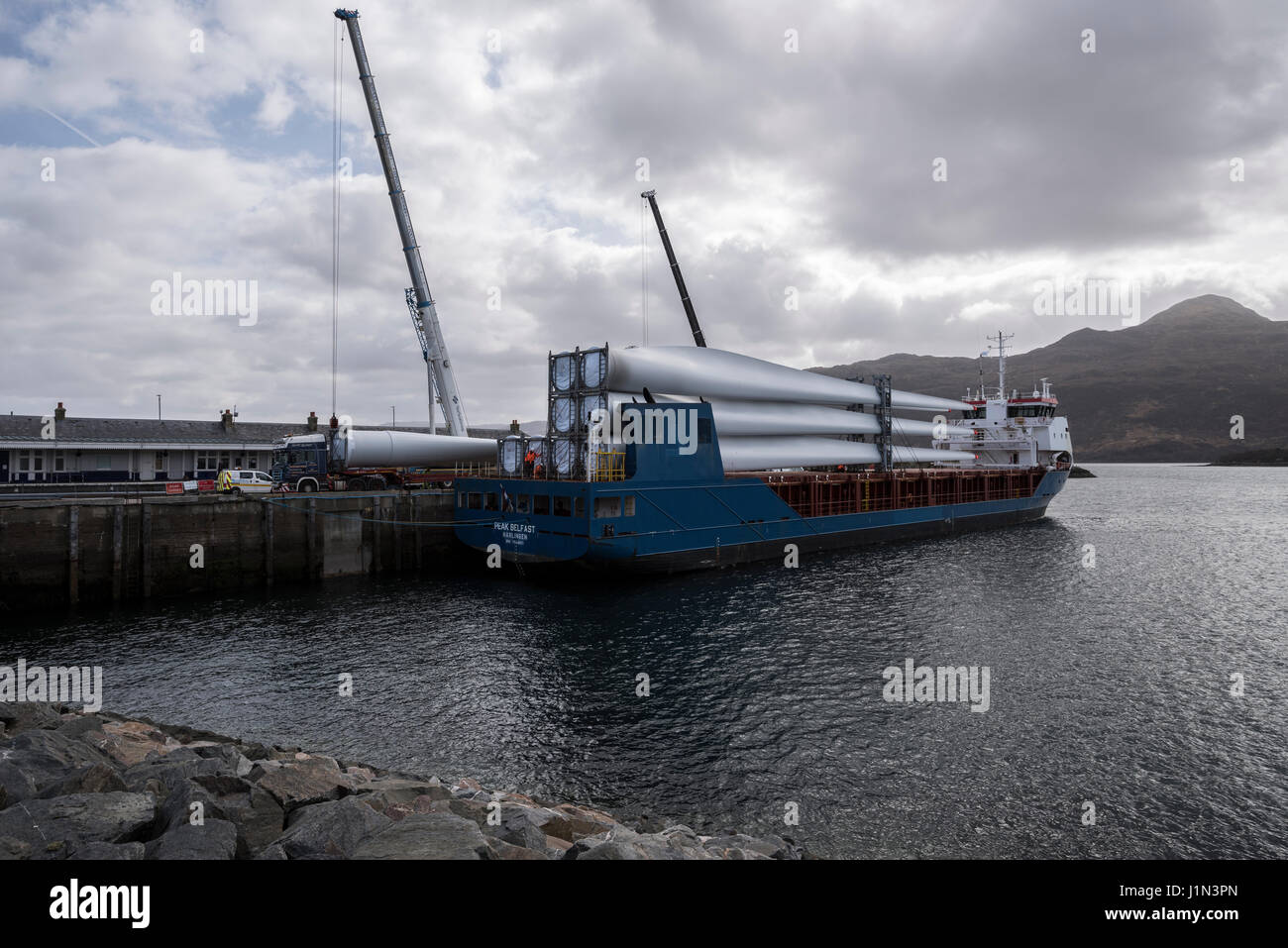Large wind turbine rotor blades being unloaded from a ship in Kyle of Lochalsh harbour onto a