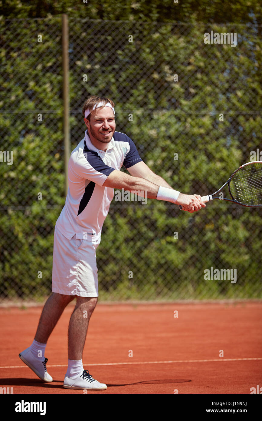 Man with racket on tennis court playing tennis, lower body part Stock Photo Alamy