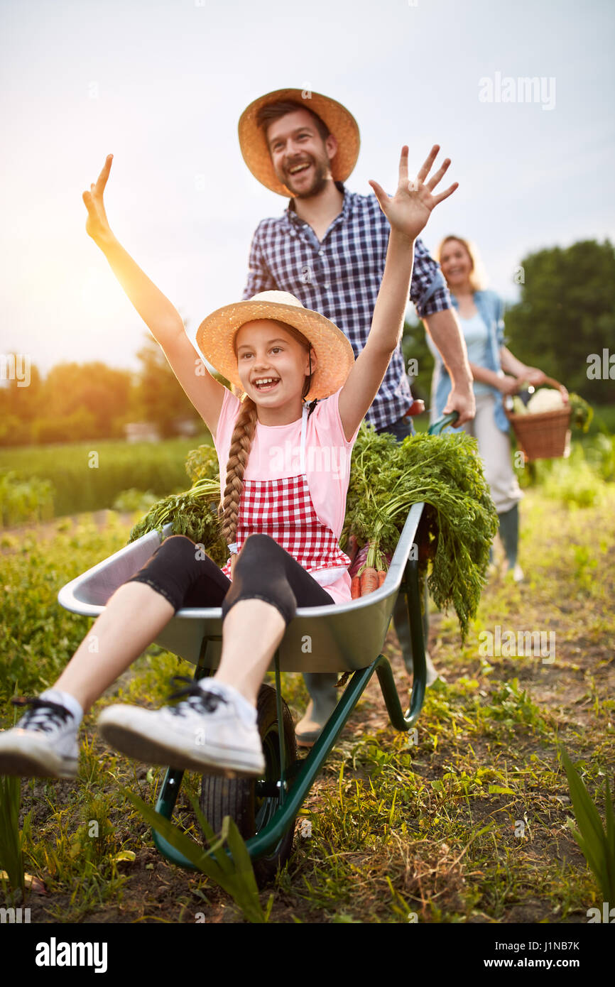 Delighted girl having fun with male farmer in vegetables garden Stock Photo