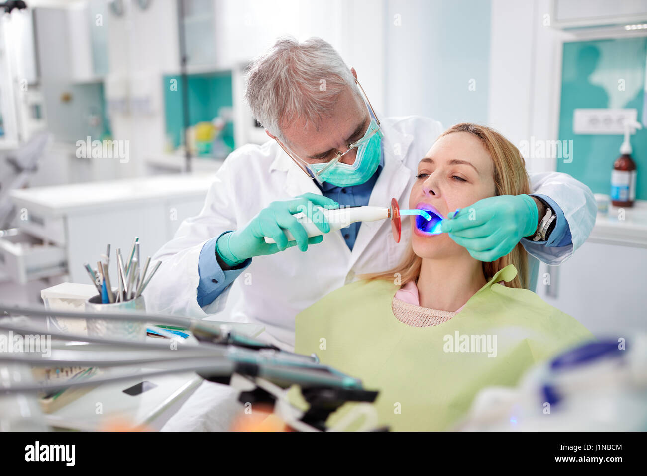 Dentist use dental light instrument for working with teeth Stock Photo