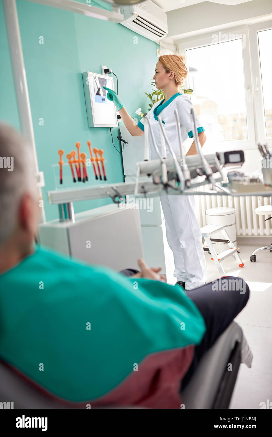 Female dentist examining dental X-ray in dental clinic Stock Photo