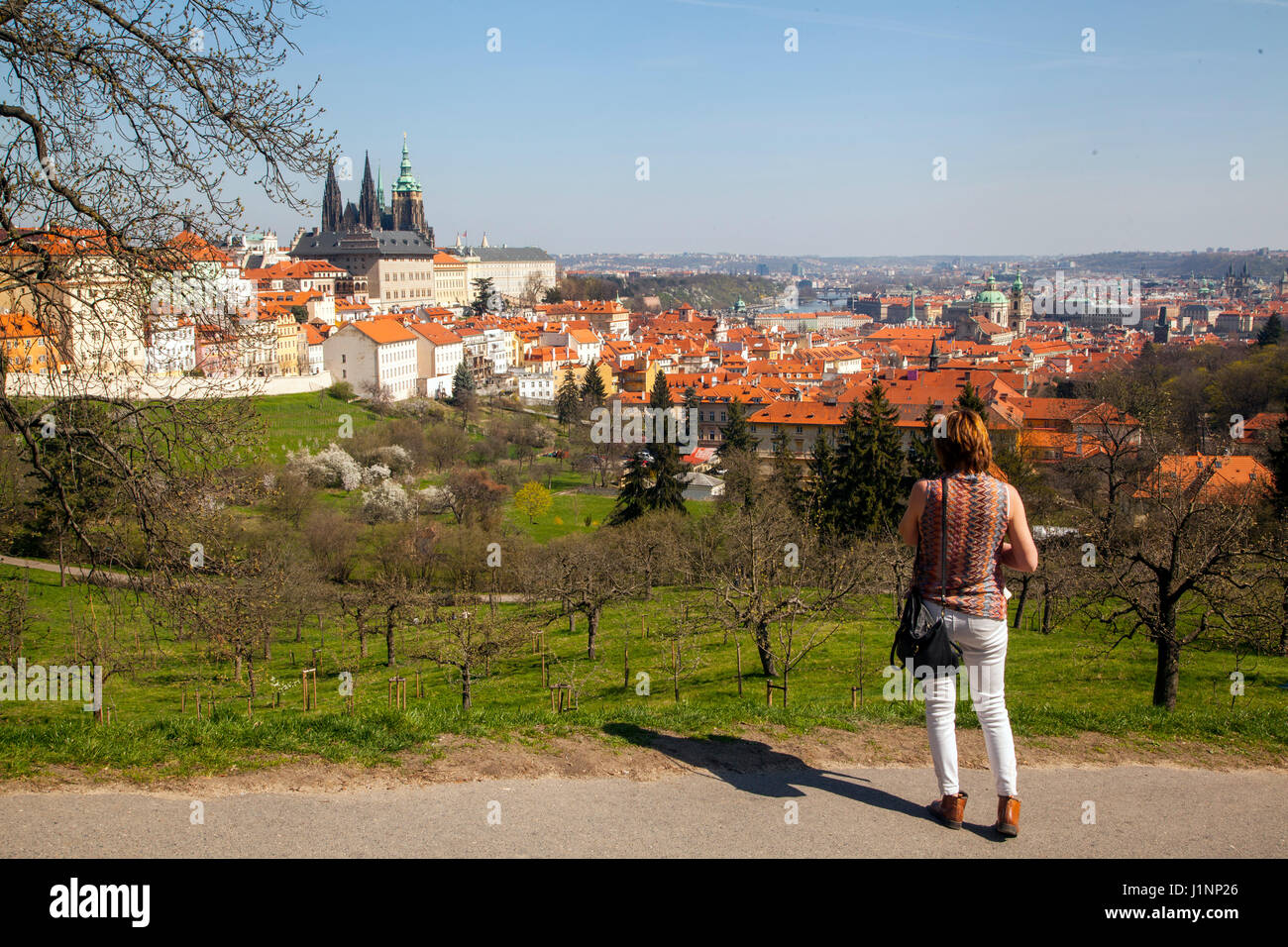 Woman admiring the view over the roof tops of Prague towards the Vltava river and its bridges Stock Photo