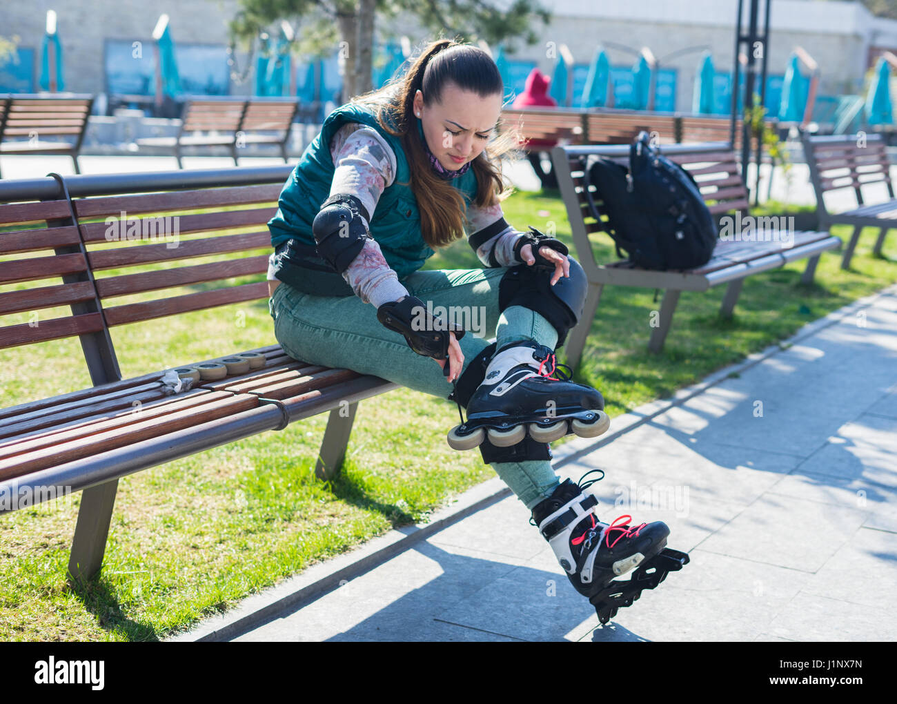 Roller girl unscrewing wheels on roller Skates with Allen key Stock Photo