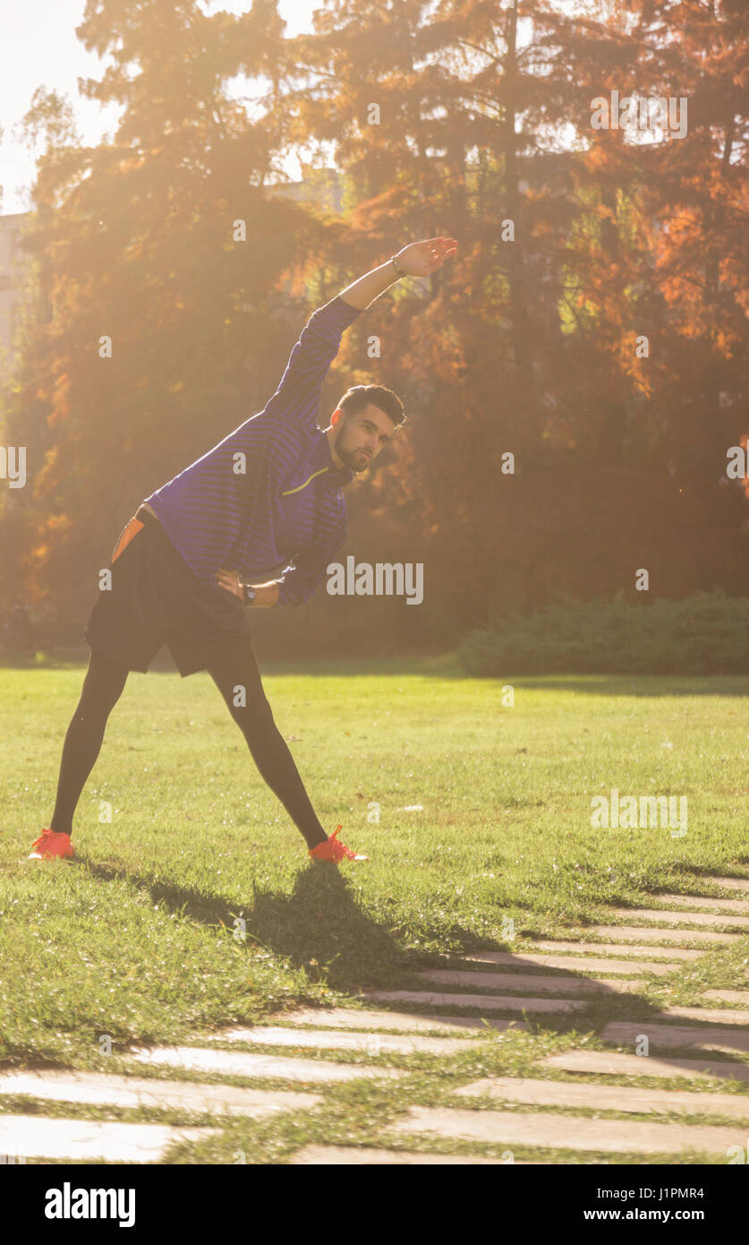 young man athlete football soccer player stretching upper body