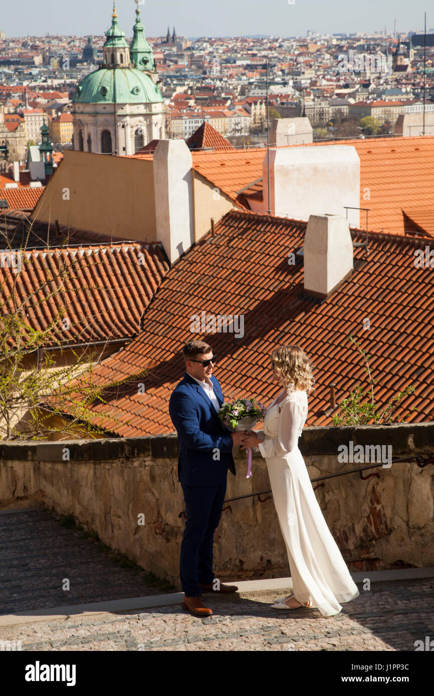 Man and woman posing for wedding photographs on the Old castle steps leading down from Prague Castle to the lesser town. Stock Photo